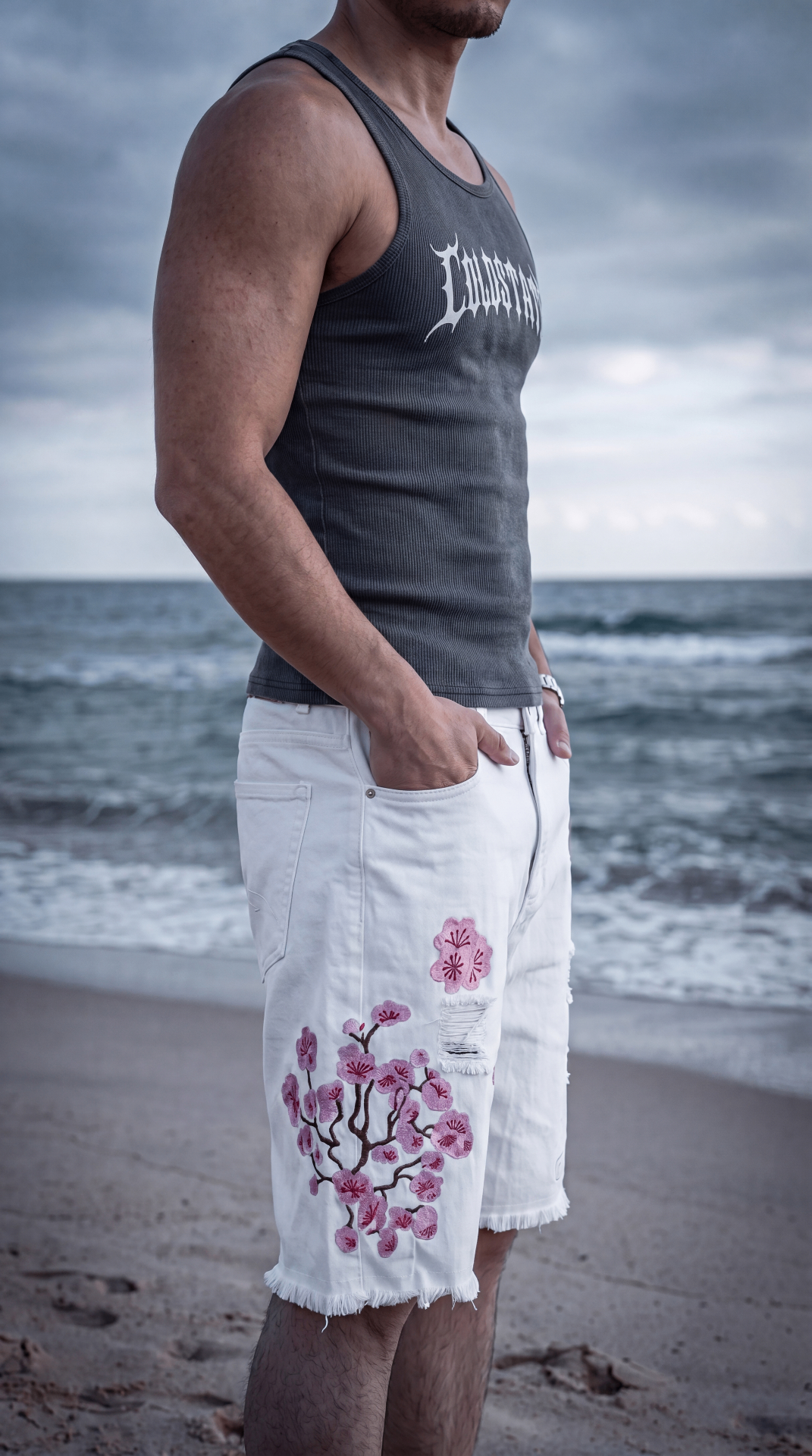 Close crop of the proposed Drop 01 tank and white embroidered shorts by the sea
